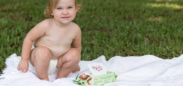 baby sitting on a grass with bamboo wet wipes