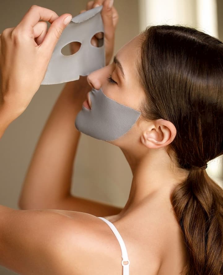 girl removing face sheet mask from her face