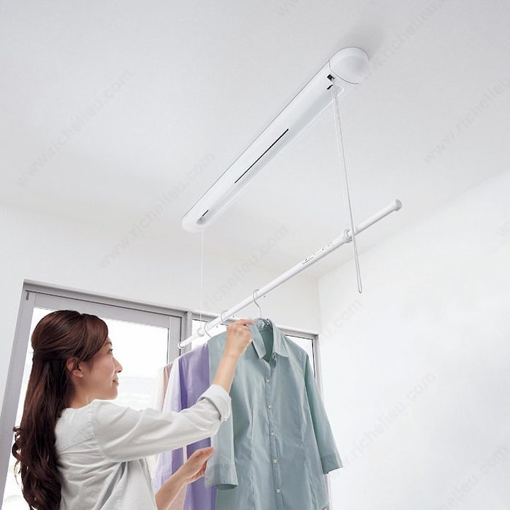 girl hanging clothes on a ceiling electric dryer