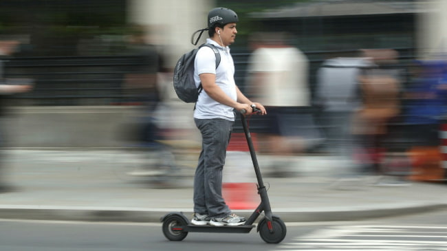 young man commuting with an electric scooter