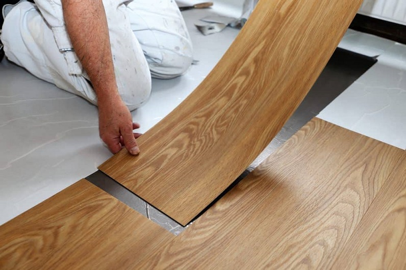 a man installing vinyl tiles 