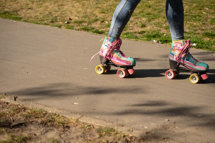 picture of a little girl in jeans and stylish roller skates in a park