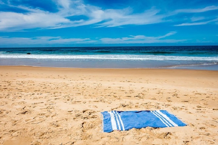 beach towel on sand and sea in background