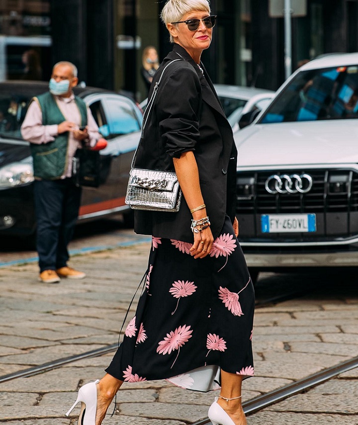 picture of a woman walking on the street wearing black floral stylish clothes  