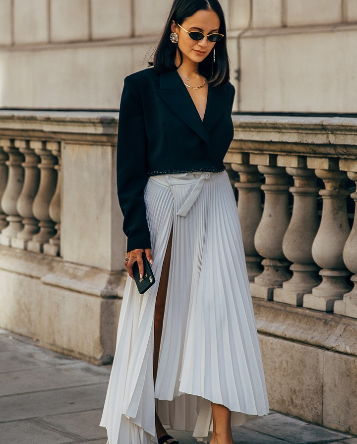 picture of a stylish woman walking beside building
