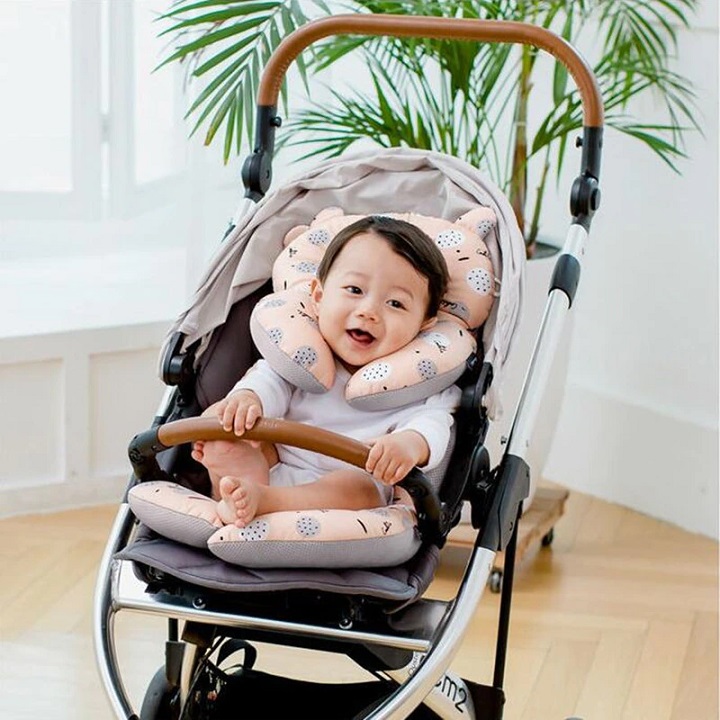 picture of a baby in a pram with a head support padded pillow 