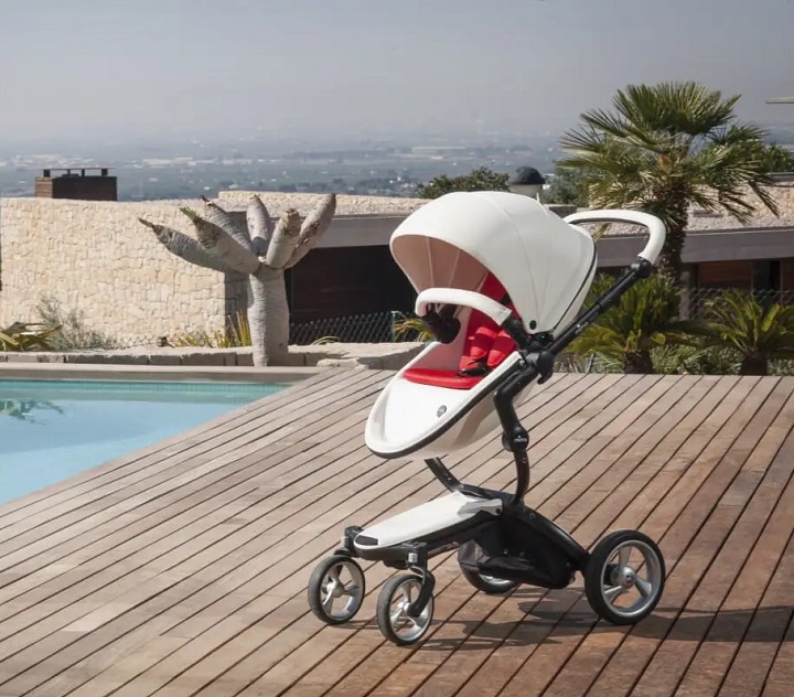picture of a baby pram with sun shade beside a pool on a hill