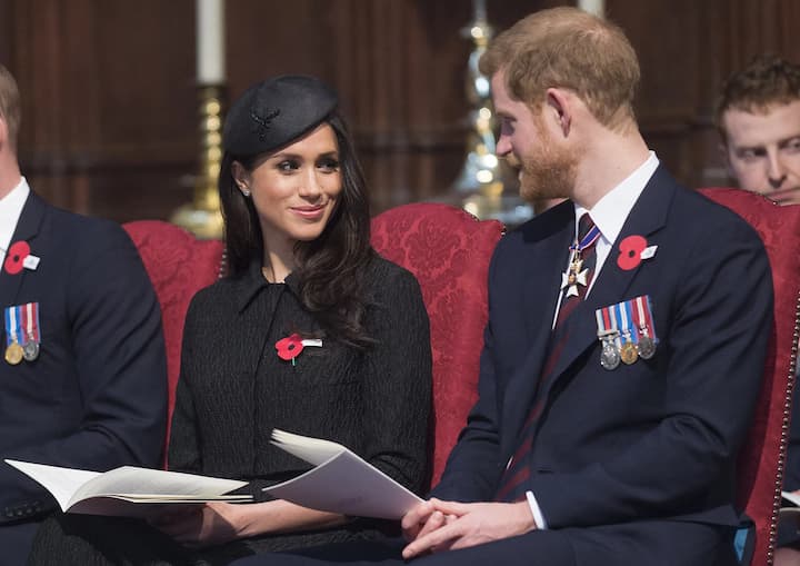 Meghan Markle and Prince Harry wearing poppy flower badges
