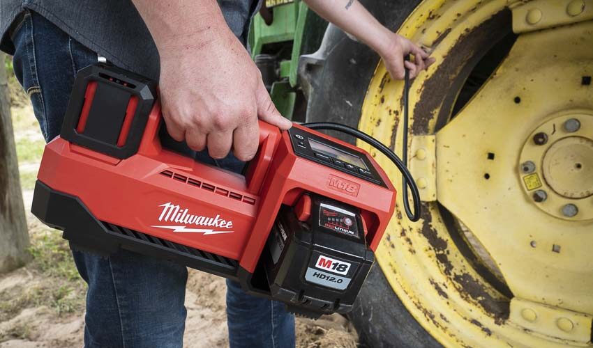Man blowing a tire with Milwaukee Cordless Hand-Carry compressor