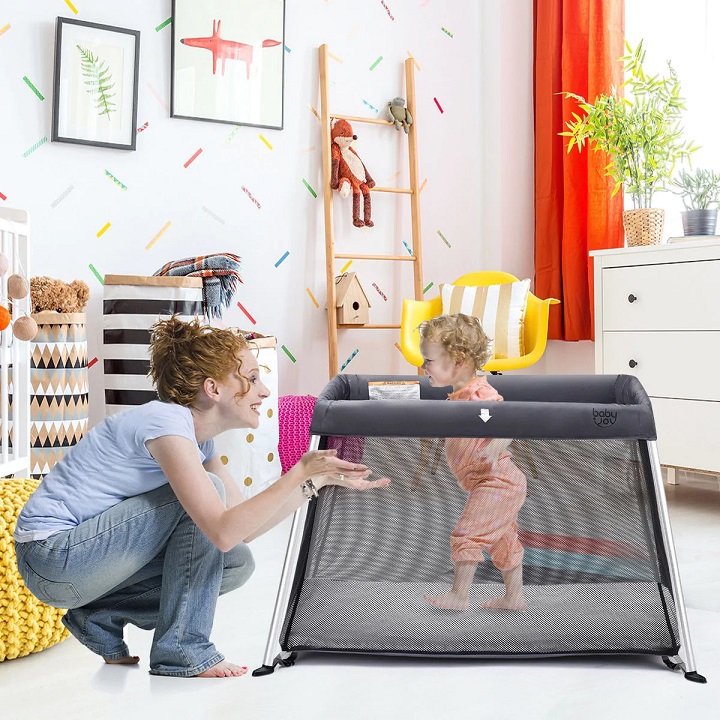 picture of a woman beside a baby in a playpen 
