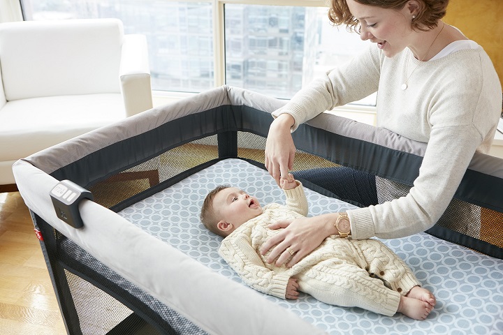 picture of a woman standing over a baby in a playpen