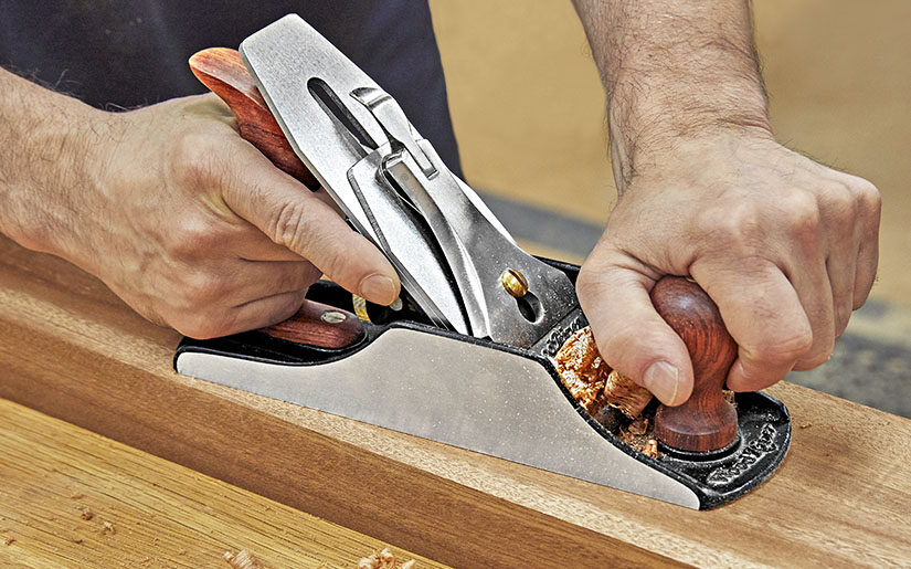 a man working with hand plane 