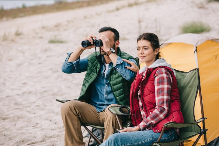 picture of persons looking through binoculars while camping 