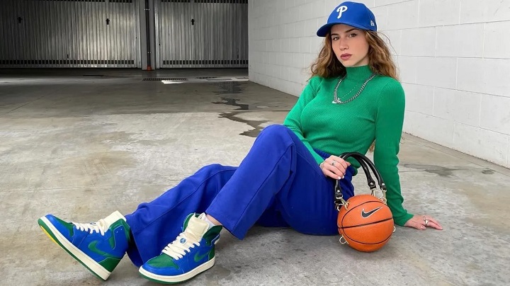 girl sitting on the ground dressed in retro style with a basketball next to her