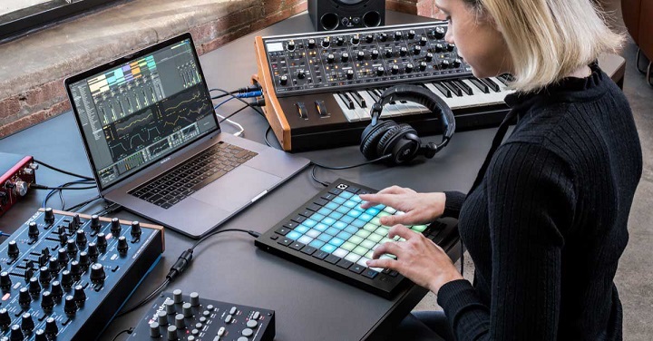 woman producing music in her studio with a keyboard midi controller