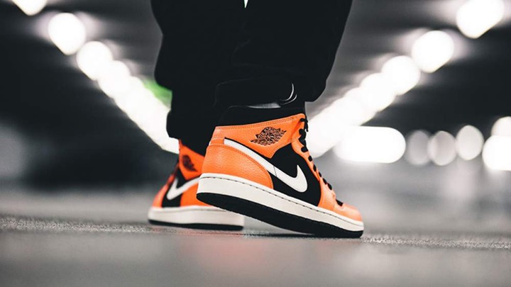 person with black jeans and mid air jordan 1's