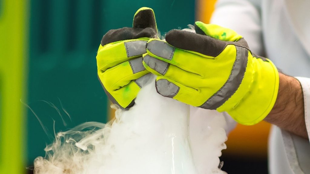 two hands with gloves handling dry ice 
