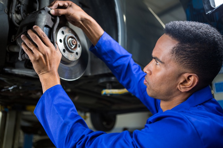 person changing car brake pad