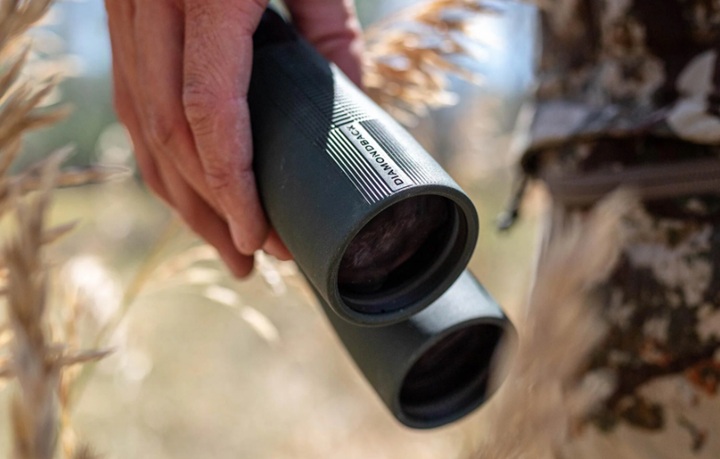 man holding 10x24 binoculars